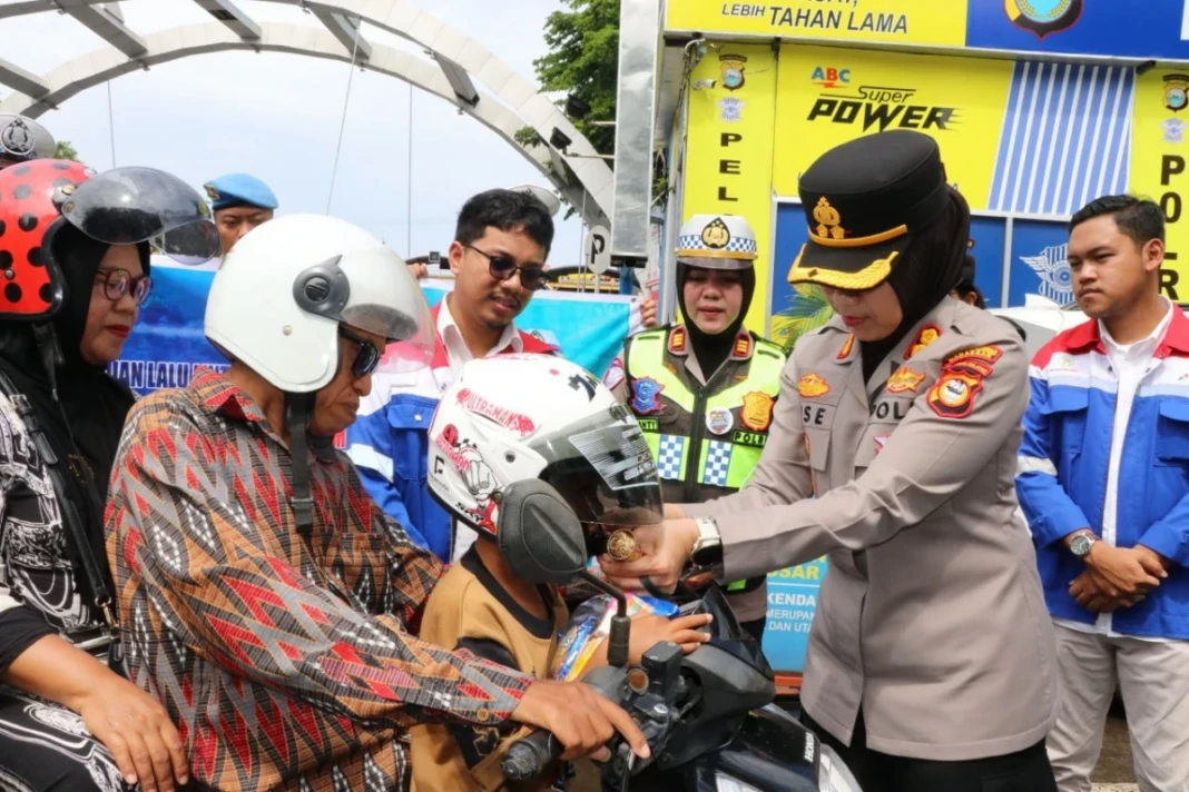 AKBP Rise Sandiyantanti memasangkan helm gratis kepada pengendara roda dua yang melanggar peraturan lalu lintas dalam Operasi pallawa 2026, Selasa