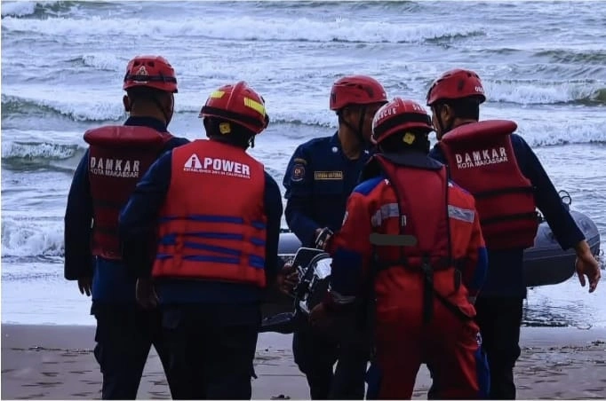 Proses evakuasi nelayan yang terseret ombak saat memasang jaring ikan di laut Makassar oleh BPBD, Senin 