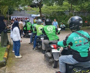 Antrean panjang para driver ojek online menunggu giliran pembagian beras 5kg dari program Baksos IKA Unhas.