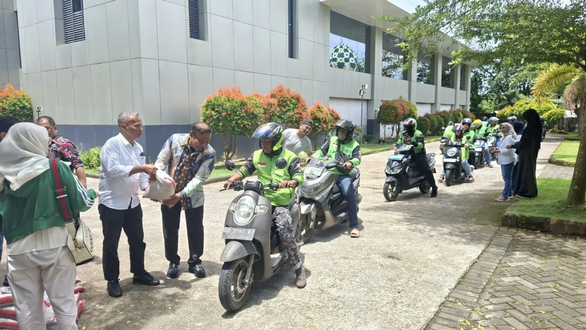 Driver ojek online mengantri menerima bantuan beras