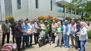 Foto bersama IKA Unhas dan driver ojek online dalam penyaluran beras program Baksos IKA Unhas. 