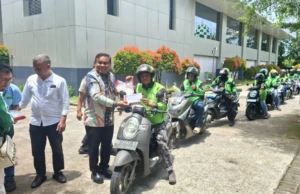 Ketua Panitia Baksos Andi Fahsar M. Padjalangi atau akrab disapa Puang Baso menyalurkan beras kepada salah satu driver ojek online.