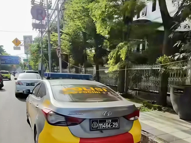 Mobil dinas milik Kapolsek Rappocini, Kompol Ismai tampak berhenti di bawah rambu larangan parkir di Jalan Ahmad Yani, Makassar.