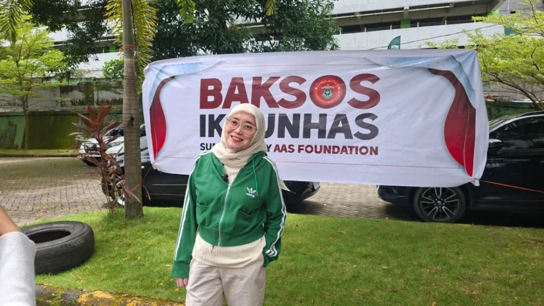 Pengurus Pusat IKA Unhas Poppy Rusdi dalam penyaluran beras ke driver online program Baksos IKA Unhas.