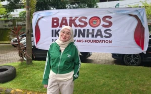 Pengurus Pusat IKA Unhas Poppy Rusdi dalam penyaluran beras ke driver online program Baksos IKA Unhas.