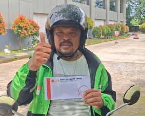 Salah satu driver ojek online saat mendapatkan bantuan beras dari Mentan Andi Amran Sulaiman melalui program baksos IKA Unhas.