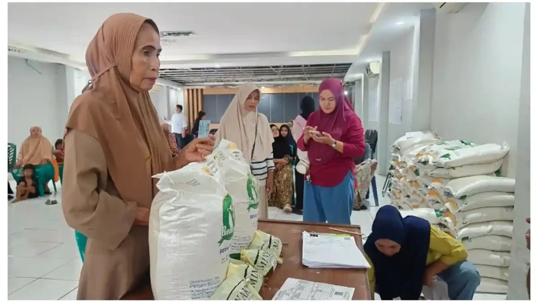 Warga Kelurahan Batua, Makassar antre mengambil bantuan pangan dan minyak goreng dari Bulog, Rabu