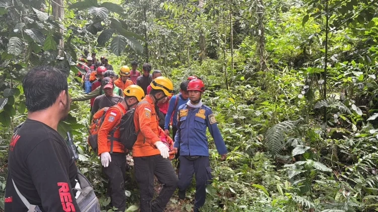 Tim SAR gabungan mengevakuasi seorang warga yang ditemukan di kawasan hutan dengan medan terjal dan vegetasi lebat. Proses evakuasi dilakukan secara hati-hati menggunakan tandu darurat.