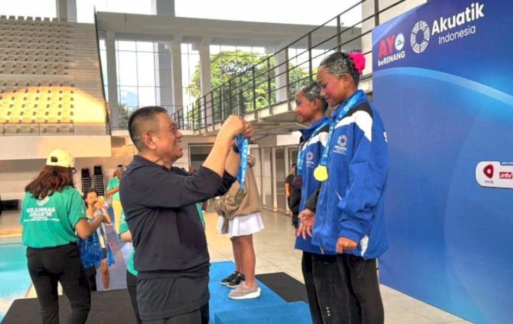 Ketua Pengprov Akuatik Indonesia Sulsel, Amirullah Nur Saenong, mengalungkan medali kepada atlet akuatik Sulsel pada Kejurnas Akuatik Indonesia 2026