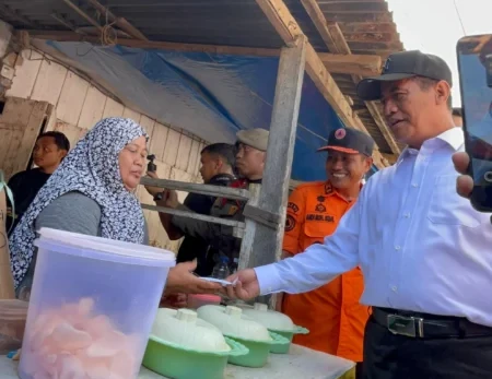 Mentan RI Andi Amran Sulaiman memborong dagangan pelaku UMKM saat mengunjungi lokasi banjir di Kelurahan Panyula, Bone