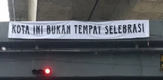 Suporter PSM Makassar memasang banner bertuliskan “Kota Ini Bukan Tempat Selebrasi” jelang laga panas melawan Persib Bandung.