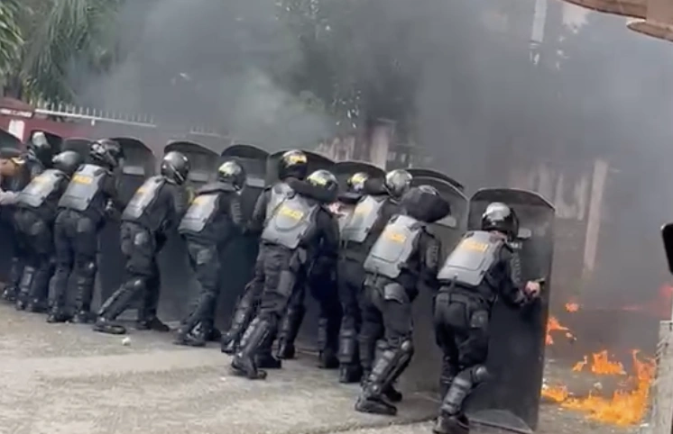Tangkapan layar video aparat kepolisian berusaha mengendalikan situasi kericuhan