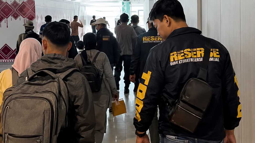 Petugas kepolisian mengawal rombongan calon pekerja migran nonprosedural di area Bandara Sultan Hasanuddin, Makassar.