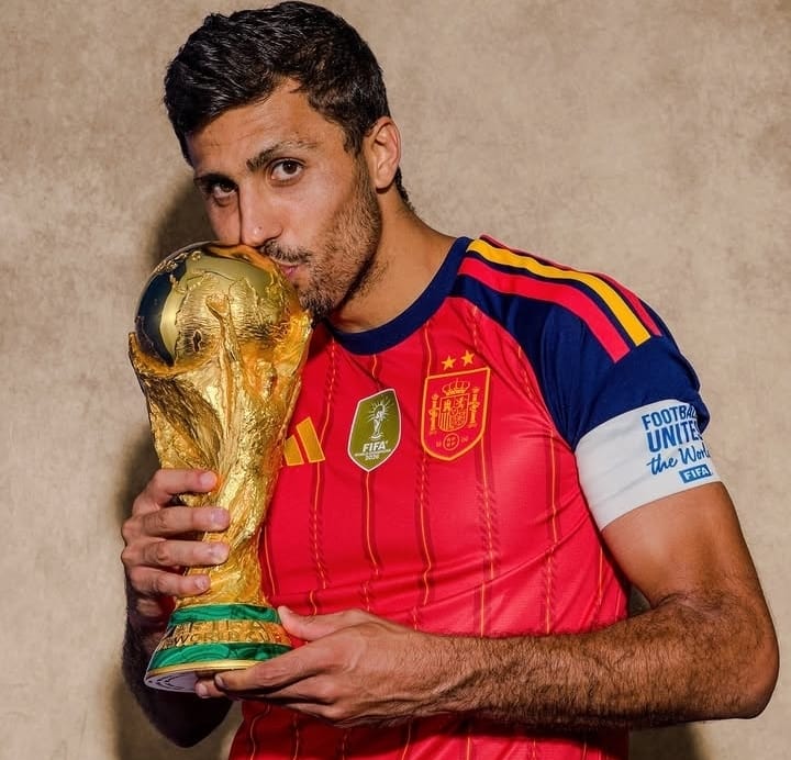 Rodri mencium trofi Piala Dunia 2026 sambil mengenakan jersey Spanyol usai membawa La Roja menjadi juara.
