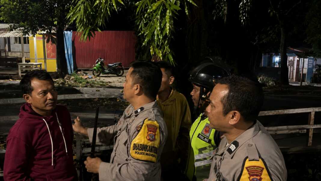 Personel polisi berjaga dan berkomunikasi dengan warga di lokasi bentrok perbatasan Mandala dan Banta-Bantaeng, Mamajang, Makassar.