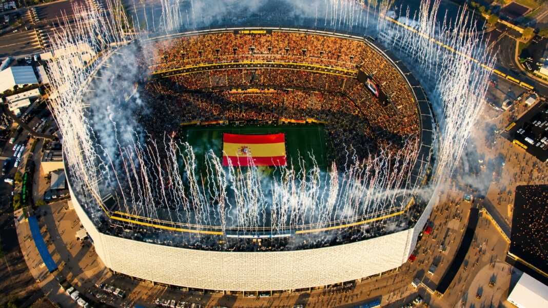 Kembang api meledak saat Spanyol merayakan gelar juara Piala Dunia 2026 di stadion, dengan bendera Spanyol terbentang di tengah lapangan.