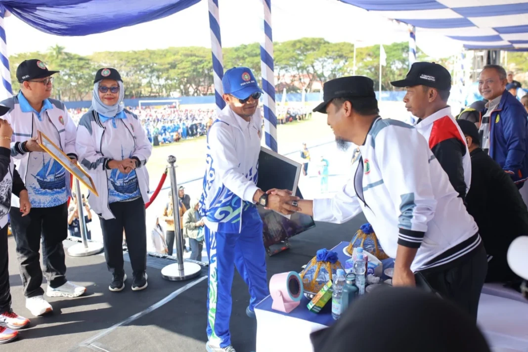 Bupati Bone Andi Asman Sulaiman menerima penghargaan dari PGRI Sulsel pada pembukaan Porsenijar 2026 