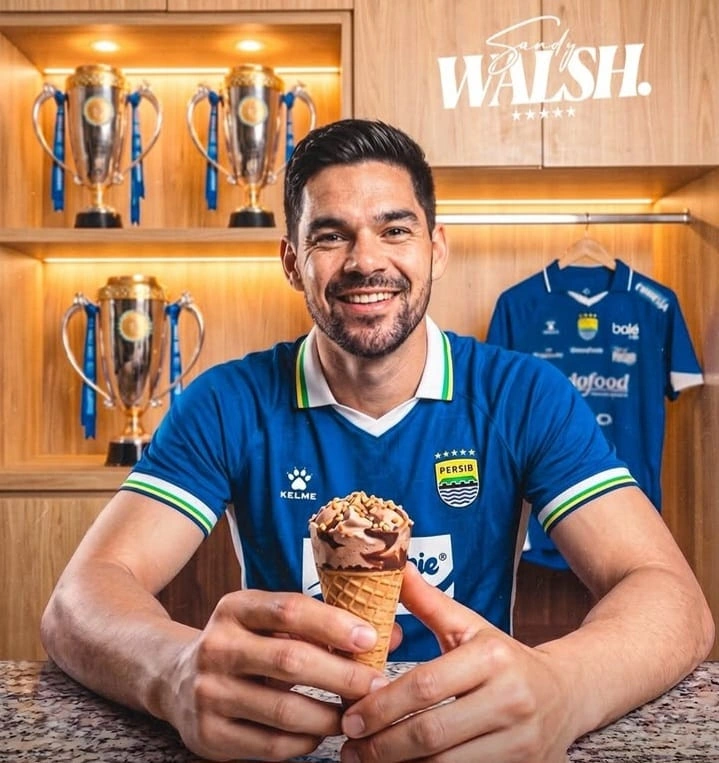 Sandy Walsh mengenakan jersey Persib Bandung sambil memegang es krim dalam unggahan perkenalan klub