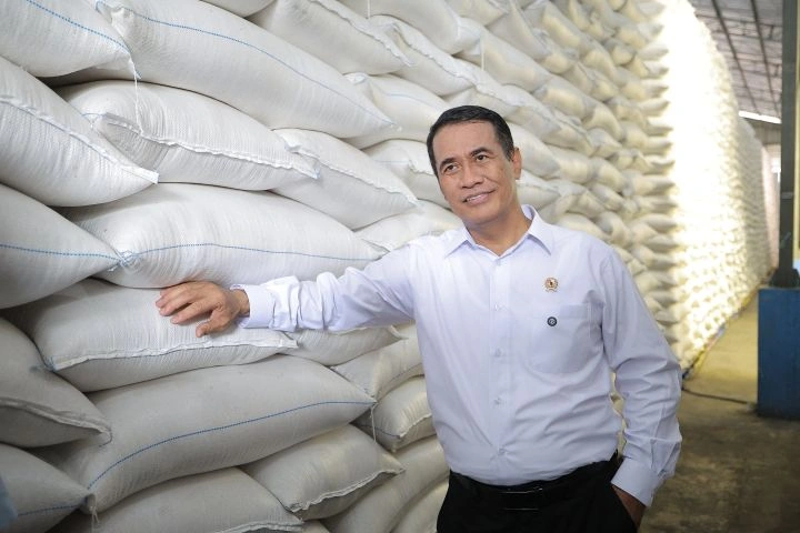 Menteri Pertanian Andi Amran Sulaiman di depan tumpukan beras