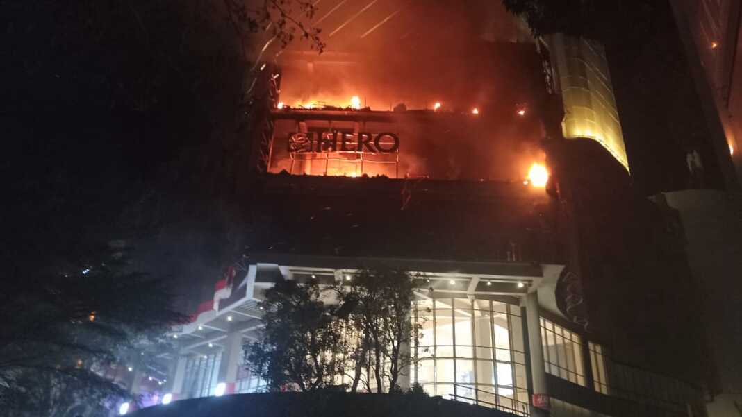 Api terlihat membakar bagian atas gedung Mal Nipah di Makassar.