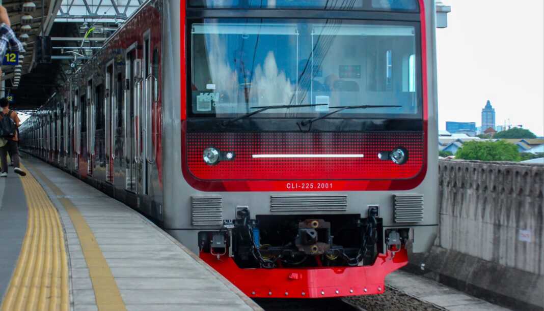 Ilustrasi kereta rel listrik KRL berhenti di peron stasiun.