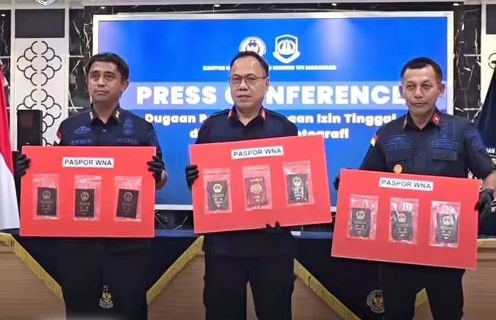 Petugas Kantor Imigrasi Makassar menunjukkan paspor WNA dalam konferensi pers dugaan penyalahgunaan izin tinggal di Makassar.