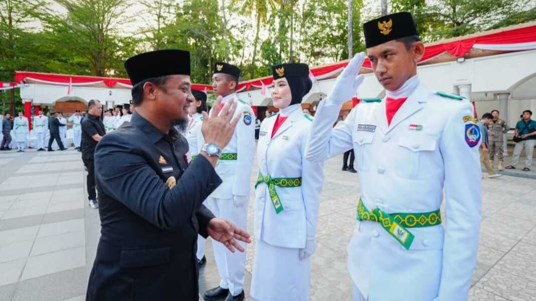 Gubernur Sulawesi Selatan Andi Sudirman Sulaiman menyalami anggota Paskibraka Sulsel 2026 usai pengukuhan di halaman Rumah Jabatan Gubernur Sulsel, Makassar, Jumat, 14 Agustus 2026.