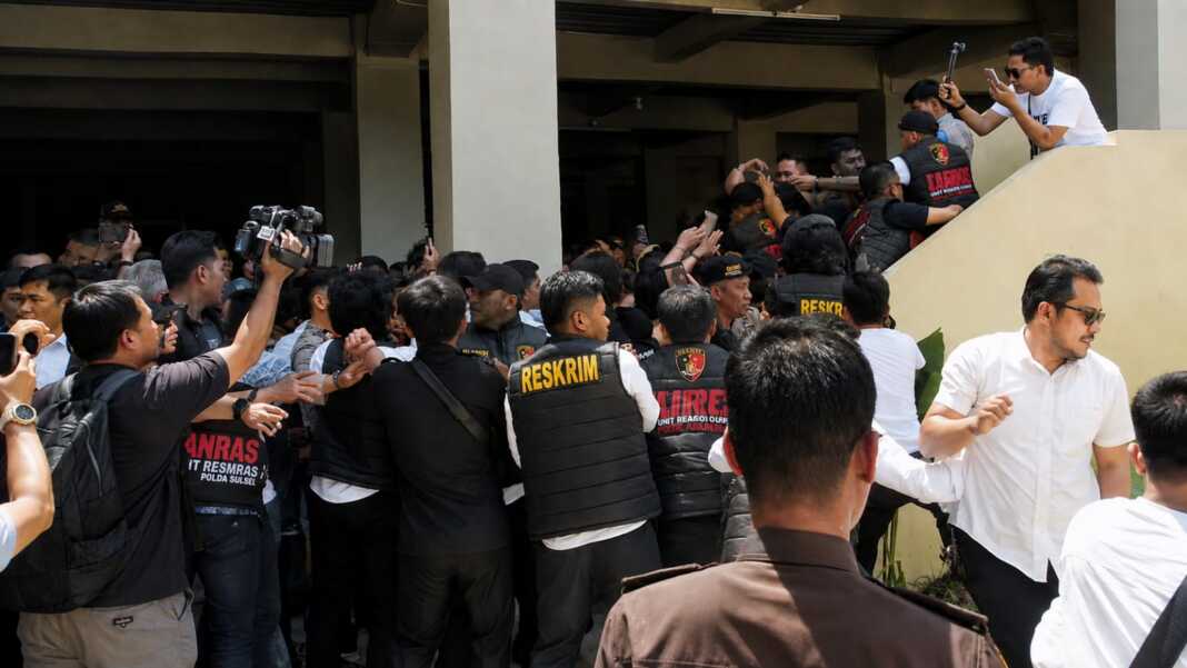 Petugas kepolisian mengamankan tersangka dan menahan kerumunan warga saat kericuhan