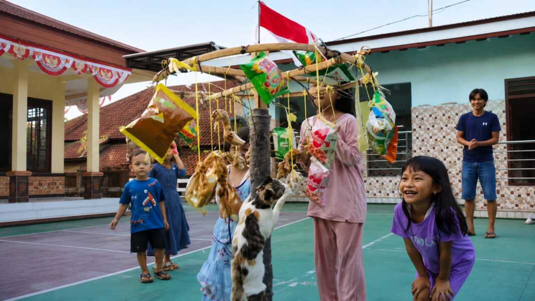 Seekor kucing memanjat tiang hadiah saat lomba panjat pinang kucing pada perayaan HUT ke-81 RI di Cibingbin.
