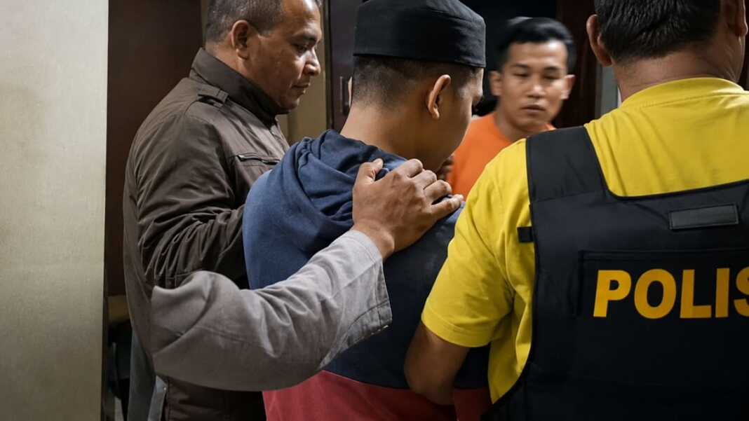 Petugas kepolisian mendampingi pria yang diamankan dalam penanganan kasus dugaan pencabulan anak di Buton, Sulawesi Tenggara.