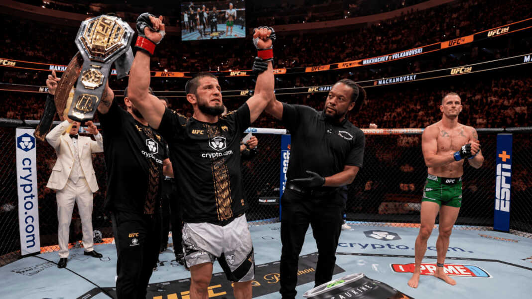 Islam Makhachev mengangkat tangan setelah dinyatakan menang atas Alexander Volkanovski di UFC 294, Abu Dhabi. Kemenangan ini mempertahankan sabuk Juara Kelas Ringan UFC. FOTO: UFC