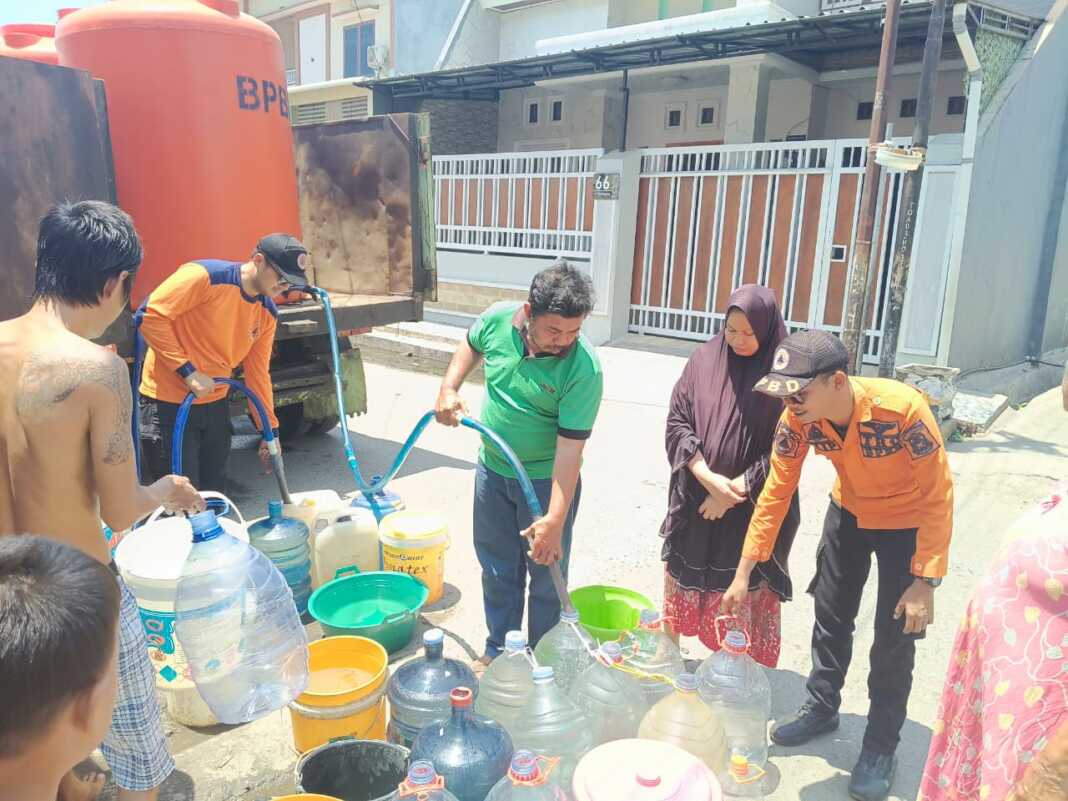 Petugas BPBD Kota Makassar membagikan air bersih pada warga yang terdampak