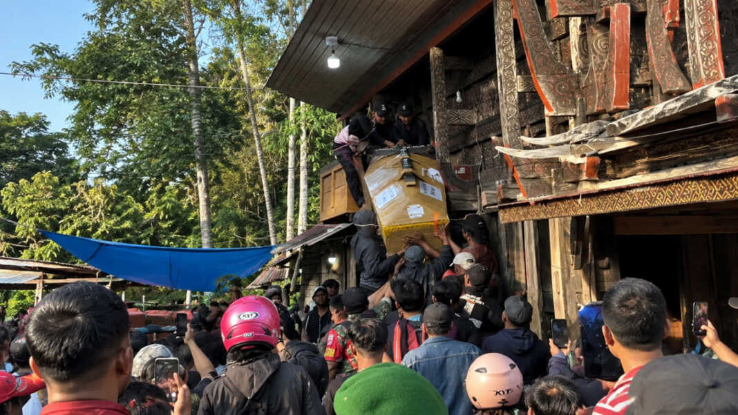Warga mengangkat peti jenazah Alm Aris Sanda korban penembakan saat tiba di rumah adat Tongkonan Toraja