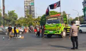 Tujuh orang anggota Gerakan Solidaritas Mahasiswa Merdeka mencoba menahan truk tronton yang melintas di Jalan Sultan Alauddin.