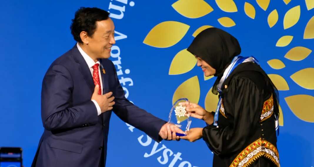 Direktur Jenderal FAO Qu Dongyu memberikan penghargaan FAO 100 Women Heroes kepada petani kopi Istiqamah dari Aceh, Indonesia, dalam World Food Forum di Roma, Italia, pada Kamis (15/10/2026).
