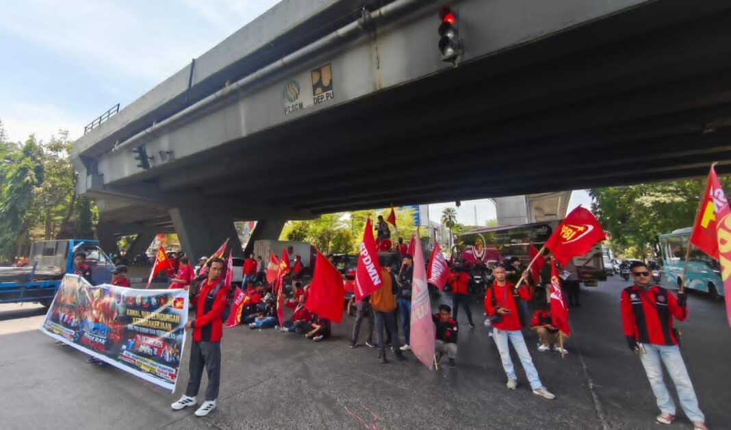 Puluhan massa buruh yang tergabung dalam Koalisi Besar Perjuangan Buruh Indonesia (KBPBI) Sulawesi Selatan menggelar aksi unjuk rasa di Fly Over Urip Sumoharjo, Makassar, Selasa (7/10/2026).
