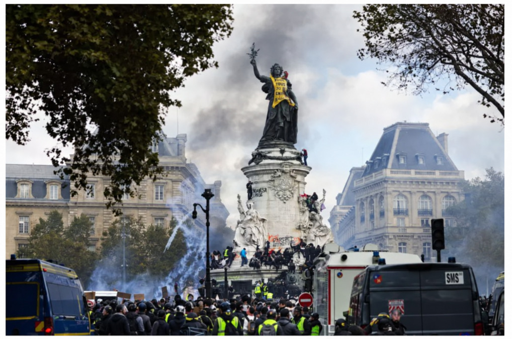 Asap menyelimuti Patung Republik yang dipasangi spanduk kuning saat demonstrasi menentang mahalnya biaya hidup di Place de la République, Paris, pada 17 Oktober 2026. ( Foto: AFP — Geoffroy Van der Hasselt).