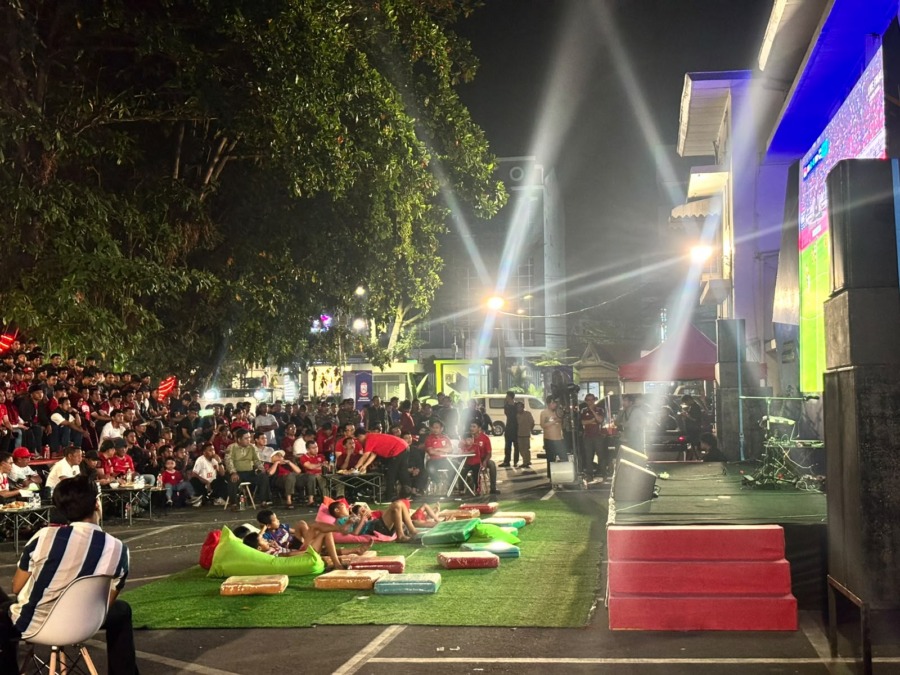 Anak-anak duduk santai di depan layar saat nonton bareng Timnas Indonesia vs Thailand di halaman Balai Kota Makassar, Senin (5/10/2026) malam.