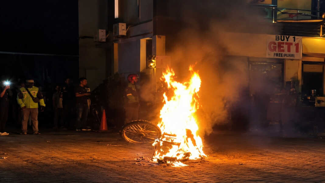 Motor Honda CRF dibakar massa dan polisi mengamankan satu pemuda setelah dugaan teror busur di Jalan Metro Tanjung Bunga, Makassar